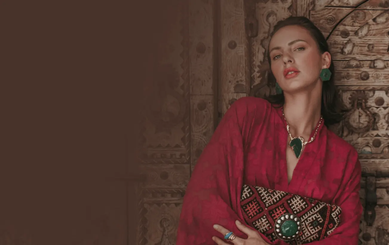 Woman in a red outfit wearing a gold pendant necklace