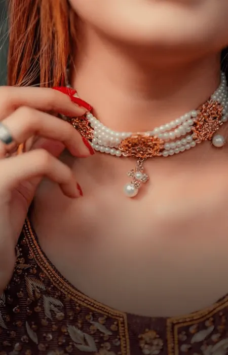 Woman wearing a gold and pearl choker necklace
